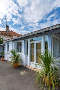 una casa blanca con plantas delante en Villa à 2 pas de la plage, en Arcachon