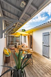 une terrasse avec une table et un parasol dans l'établissement Villa à 2 pas de la plage, à Arcachon