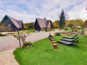 a yard with a row of benches on the grass at Plitvice Luxury Etno Garden in Plitvička Jezera