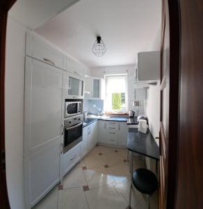 a kitchen with white appliances and a black table at Apartament 15 min od morza in Gdańsk