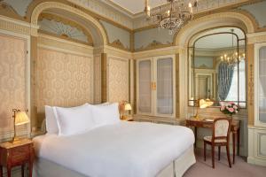 a hotel room with a large bed and a large mirror at Hôtel Raphael in Paris