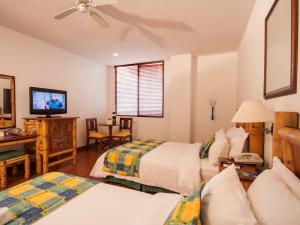 a hotel room with two beds and a television at Armenia Hotel in Armenia