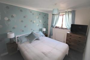 a bedroom with a bed and a flat screen tv at 3 Bed House - Garden & Parking - Quiet Cul De Sac in Doncaster