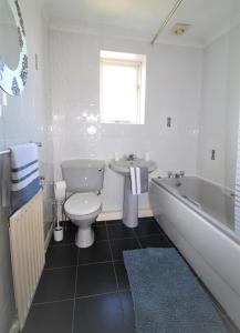 a bathroom with a tub and a toilet and a sink at 3 Bed House - Garden & Parking - Quiet Cul De Sac in Doncaster