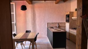 a kitchen with a wooden table and a table and chairs at Atypique in Châteauneuf-de-Gadagne