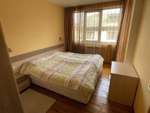 um pequeno quarto com uma cama e uma janela em Bansko Ski Apart em Bansko