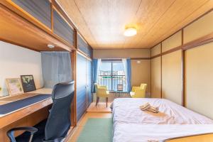 Habitación pequeña con cama, escritorio y sillas. en 汐の香 - shio no kaori en Odawara