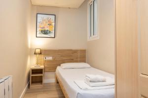 バルセロナにあるApartEasy - Family 4-Bedroom Apartmentのベッドと窓が備わる小さな客室です。