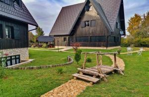 ein Holzhaus mit einer Schaukel davor in der Unterkunft Plitvice Luxury Etno Garden in Plitvička Jezera