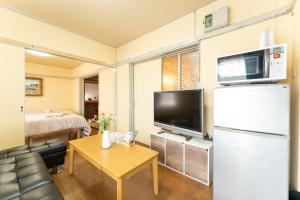 uma pequena sala de estar com um frigorífico e uma mesa em 汐の香 - shio no kaori em Odawara