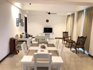 uma sala de estar com uma mesa branca e cadeiras em Apartment314 Oceanfront condos Nilaveli em Triquinimale