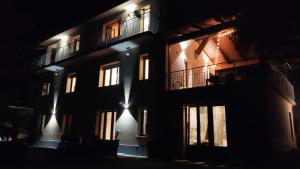 un edificio iluminado con ventanas por la noche en La casa dei nonni 3,0, en Carema