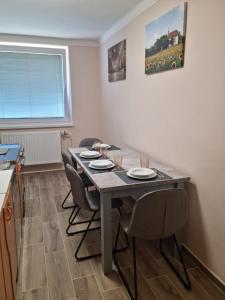 a dining room table with four chairs in a kitchen at Ubytovanie Na Hlavnej in Strekov