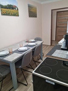y cocina con mesa, sillas y fogones. en Ubytovanie Na Hlavnej, en Strekov