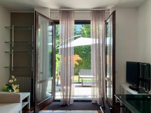 uma sala de estar com uma porta de vidro deslizante para um pátio em Mysa Properties - Accogliente bilocale nei pressi della Villa Reale - Monza em Monza