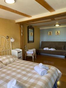 a bedroom with two beds and a couch in a room at Casa Rural La Mansion in La Toba