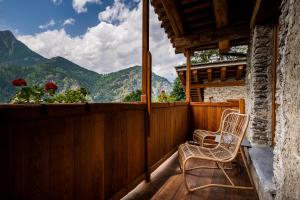 two chairs on a balcony with a view of mountains at Brieis Relais Alpino in Marmora