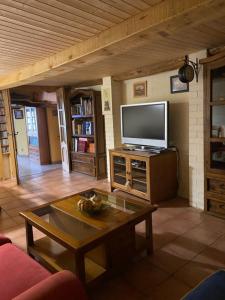 een woonkamer met een tv en een salontafel bij Casa Rural La Mansion in La Toba