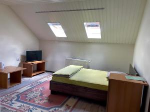 sypialnia z łóżkiem, telewizorem i stołem w obiekcie Kaufman w mieście Konopnitsa