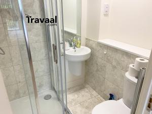 a bathroom with a shower and a toilet and a sink at Travaal.©om - 2 Bed Serviced Apartment Farnborough in Farnborough