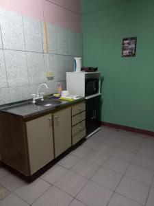 a kitchen with a sink and a refrigerator at La casita de abu! in Salta