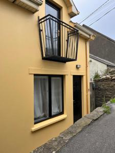 a yellow house with a balcony on the side of it at The Beach House in Lahinch