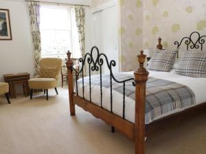 - une chambre avec un lit, une chaise et une fenêtre dans l'établissement Allerton House, à Jedburgh