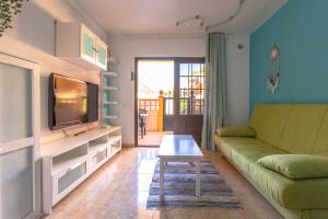 een woonkamer met een bank en een tv bij IRIS Holiday House Fuerteventura in Costa de Antigua