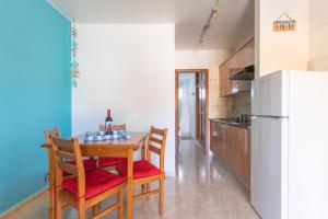 een keuken met een tafel, stoelen en een koelkast bij IRIS Holiday House Fuerteventura in Costa de Antigua