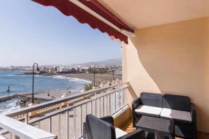 balcón con sillas y vistas a la playa en Piso en primera linea con vistas directas al mar, en Melenara