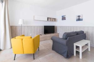 sala de estar con sofá y TV en Piso en primera linea con vistas directas al mar en Melenara