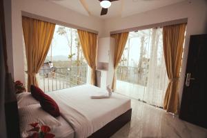 a bedroom with a bed and a large window at Paadi Holidays Idukki in Idukki