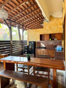 a kitchen with a large wooden table and benches at Bima Sakti Homestay Echo Beach Canggu in Canggu
