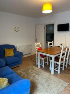 a living room with a table and a blue couch at The Beach House in Lahinch