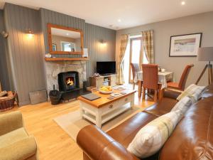 a living room with a couch and a fireplace at Cedar in Newtonmore