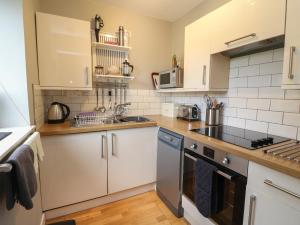 a kitchen with a sink and a stove top oven at Cedar in Newtonmore