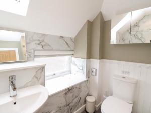 a white bathroom with a sink and a toilet at Douglas Fir in Newtonmore +32 photos