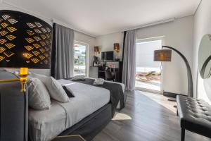 アテネにあるAthenian Riviera Hotel& Suitesのベッドルーム1室(ベッド1台付)、リビングルームが備わります。