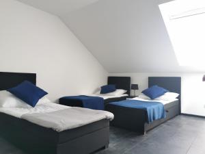three beds with blue pillows in a room at Domki Black Pearl Mielno basen sauna jacuzzi in Mielno +40 photos