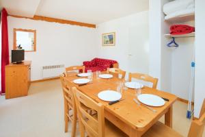 a dining room with a wooden table and chairs at Les Balcons PROCHE PARC NATIONAL VANOISE appartements 2 pieces 6 pers MONTAGNE ALP in Termignon