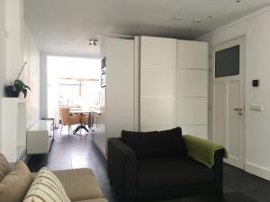 sala de estar con sofá y silla en Appartement aan De Zuid-Willemsvaart Den Bosch, en De Pettelaar