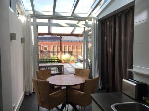 comedor con mesa, sillas y ventana en Appartement aan De Zuid-Willemsvaart Den Bosch, en De Pettelaar