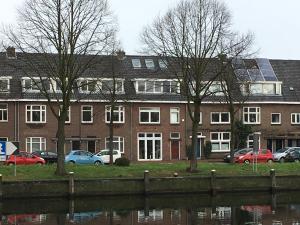 un edificio con coches estacionados junto a un cuerpo de agua en Appartement aan De Zuid-Willemsvaart Den Bosch en De Pettelaar
