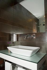 W łazience znajduje się biała umywalka i lustro. w obiekcie Casas do Regato w mieście Castelo Branco