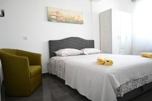 a bedroom with a bed with a pair of yellow shoes on it at Đuričić Apartmani in Budva