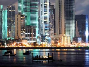 een skyline van de stad 's nachts met boten in het water bij Novotel Panama City in Panama-Stad