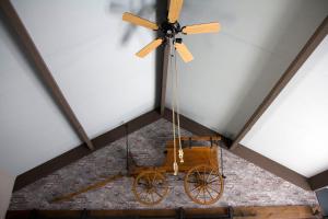 a ceiling fan and a wagon hanging from a ceiling at De Deel - Vakantiehuisje Veluwe in Ede
