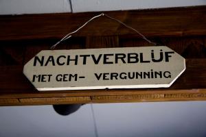 a sign that says net germ preventing hanging on a wall at De Deel - Vakantiehuisje Veluwe in Ede