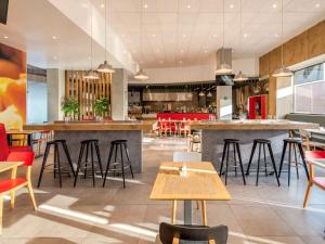 a restaurant with tables and chairs and a bar at Ibis Queretaro in Querétaro