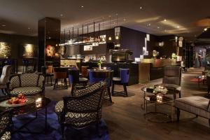 a restaurant with tables and chairs and a bar at QT Wellington in Wellington